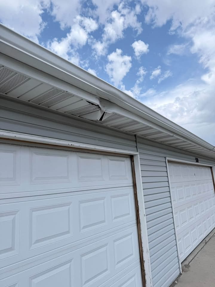 Damaged section of gutter along a garage roofline