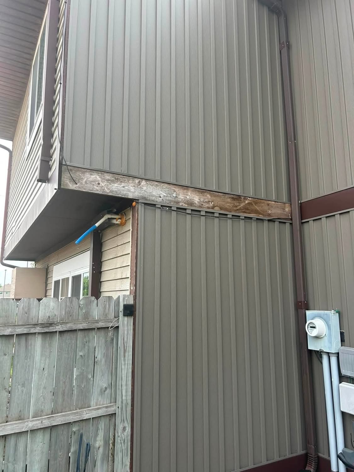 Damaged exposed wood trim board on exterior siding before repair